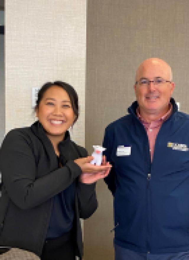 Kathy Truong holding up a UC Davis promotional cow with Brian Risi 