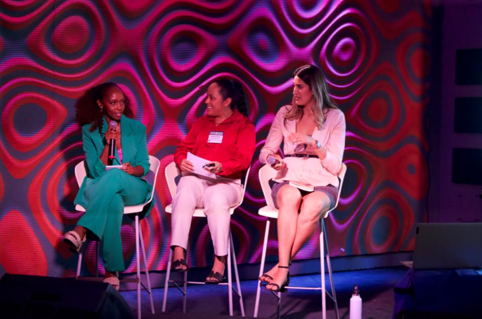 Esther Muriithi, Jocelyn Guzman, Leticia Garay sitting on a stage as part of a panel