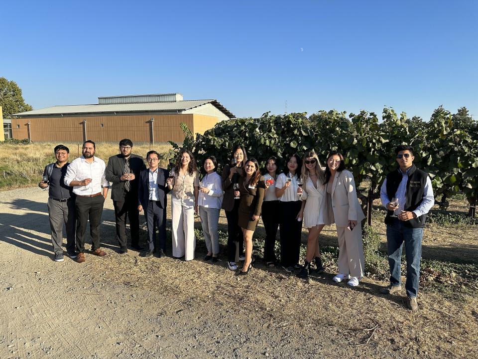 Daniela Mallard Juarez and her fellow MSBA students standing in a grape orchard at the UC Davis campus