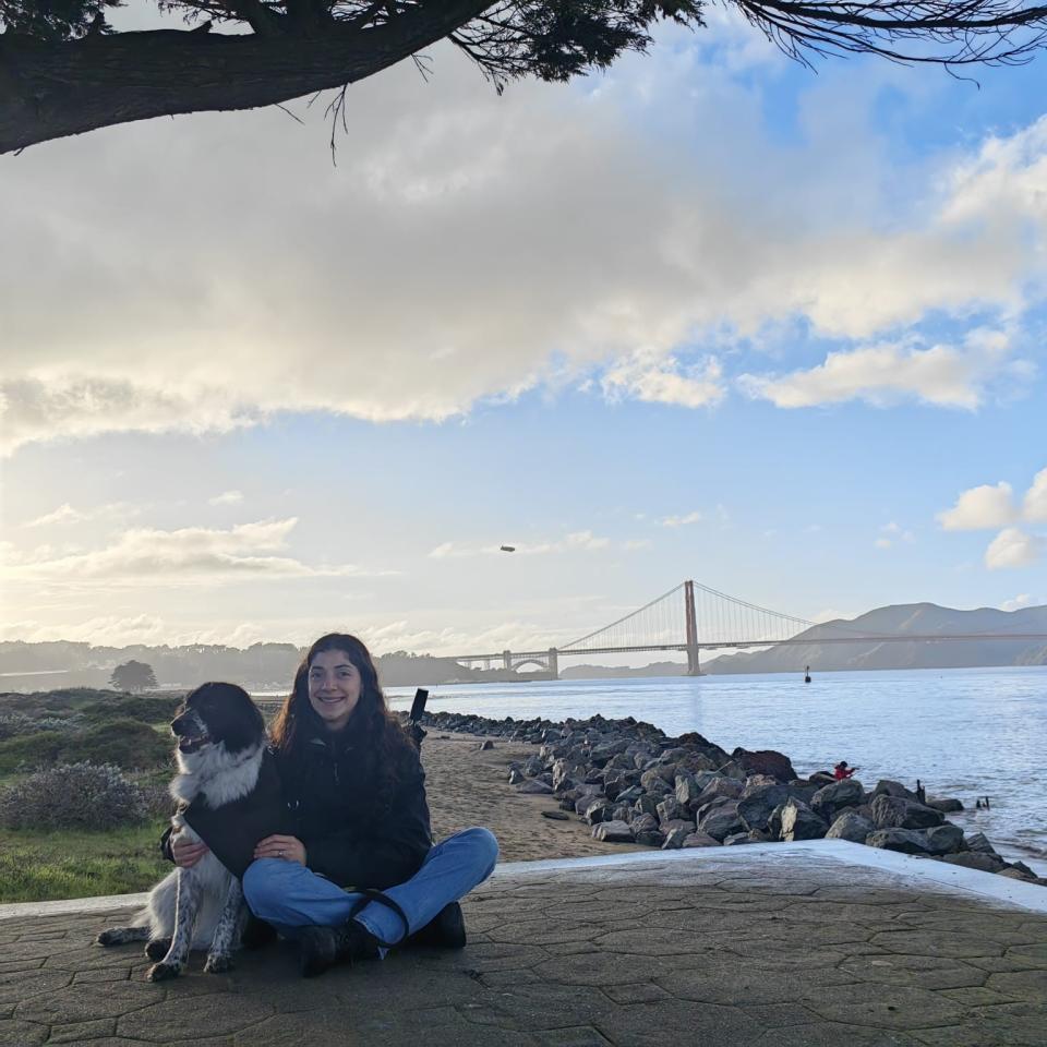 Daniela Mallard Juarez with a dog with the Golden Gate Bridge in the background