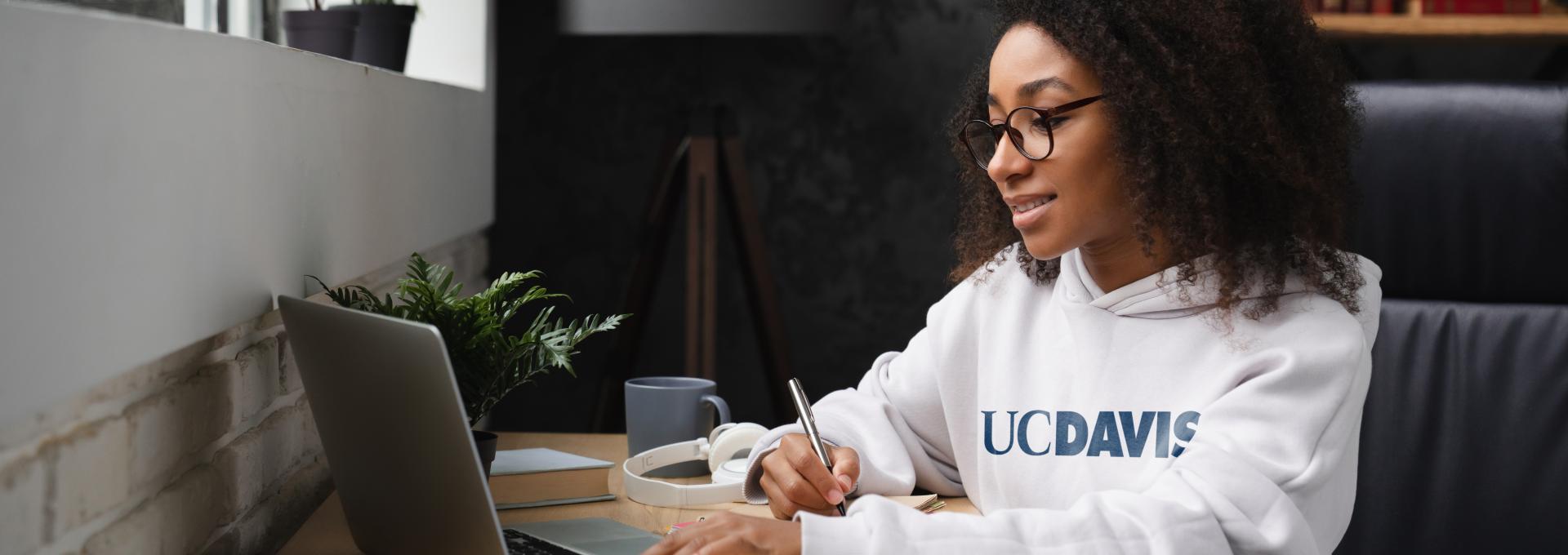 Woman at keyboard wearing UC Davis sweatshirt