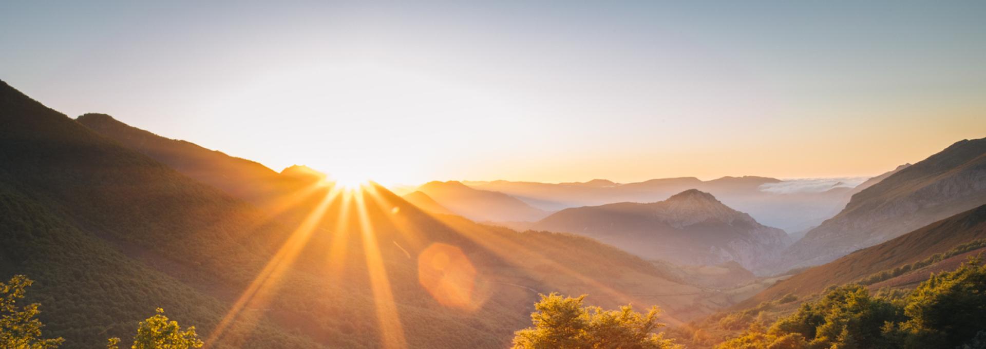 Scenic view of the sun rising over mountains stock photo