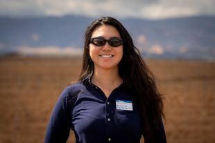 Sarah Deng standing in a field, wearing sunglasses
