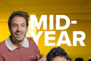 Three people facing the camera in a meeting room with "MID-YEAR CHECK IN" written in large white letters over the image.