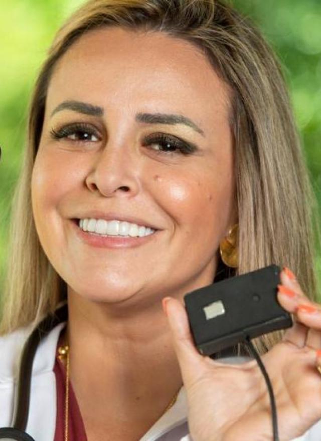 Doctor holding up mobile phone and attached sensor