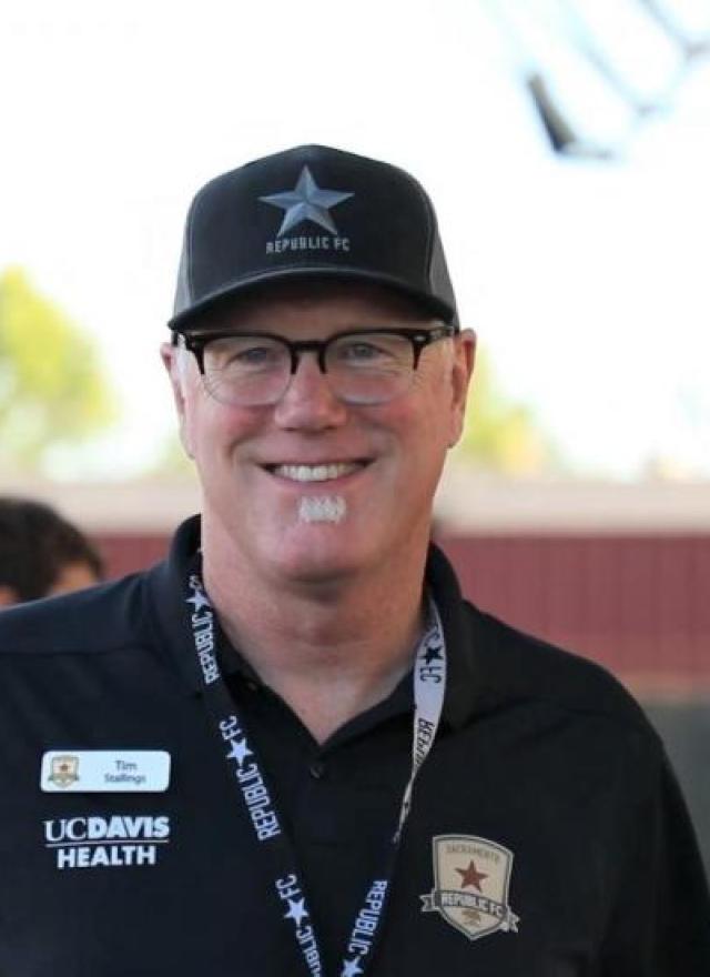 Portrait of Tim Stallings in a black hat and polo shirt