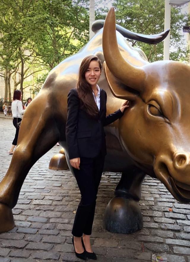Lizzy Yi MSBA 21 takes a photo with the famous 'Charging Bull' on Wall Street