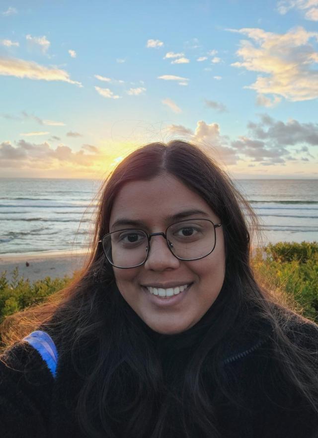 woman smiling in front of a sunset