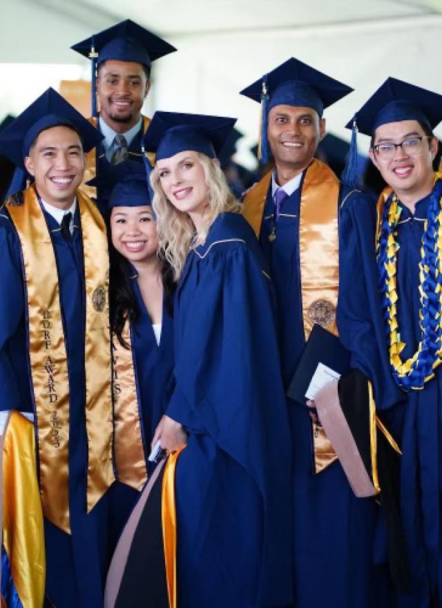 A group of Bay Area MBA students dressed in graduation caps and gowns