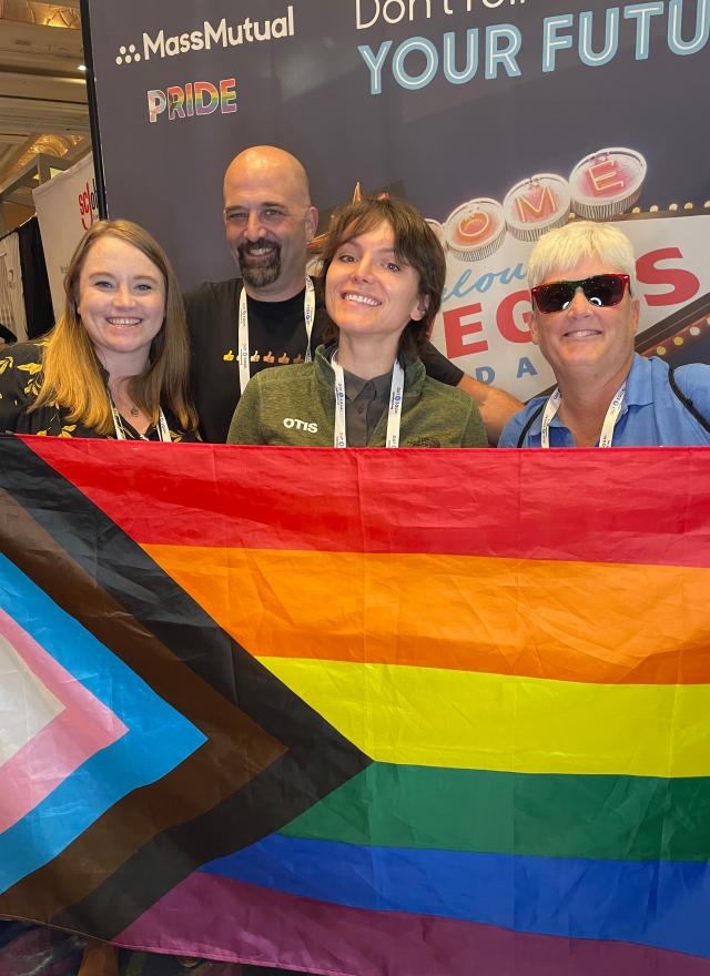 Alexandra von Klan holding a rainbow flag with her coworkers