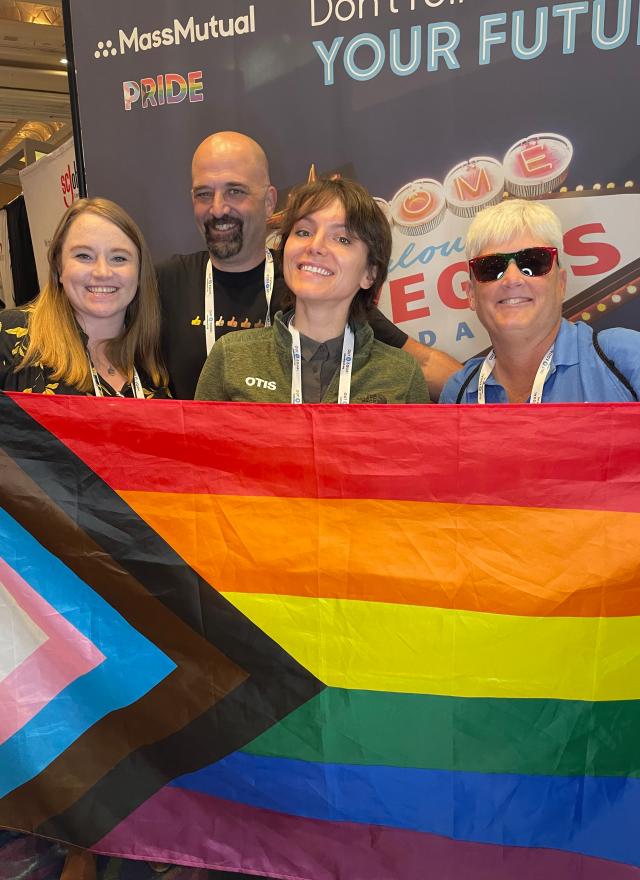 Alexandra von Klan holding a rainbow flag with her coworkers