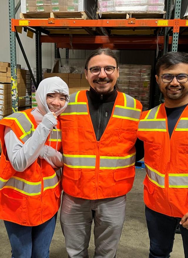 Sayar Banner Banerjee and two other students wearing safety vest at a warehouse