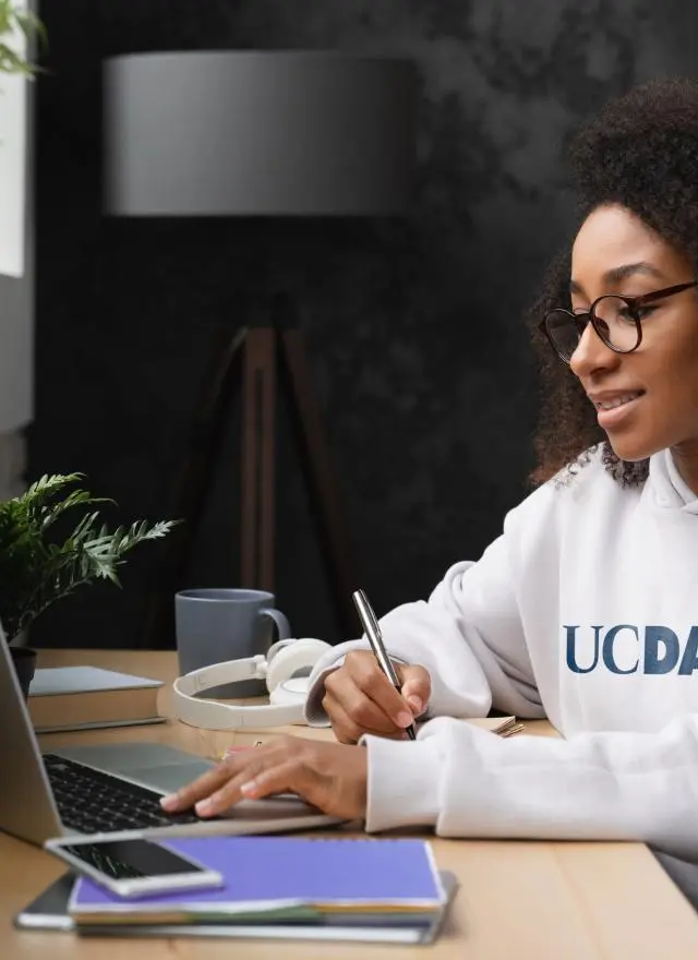Woman at keyboard wearing UC Davis sweatshirt