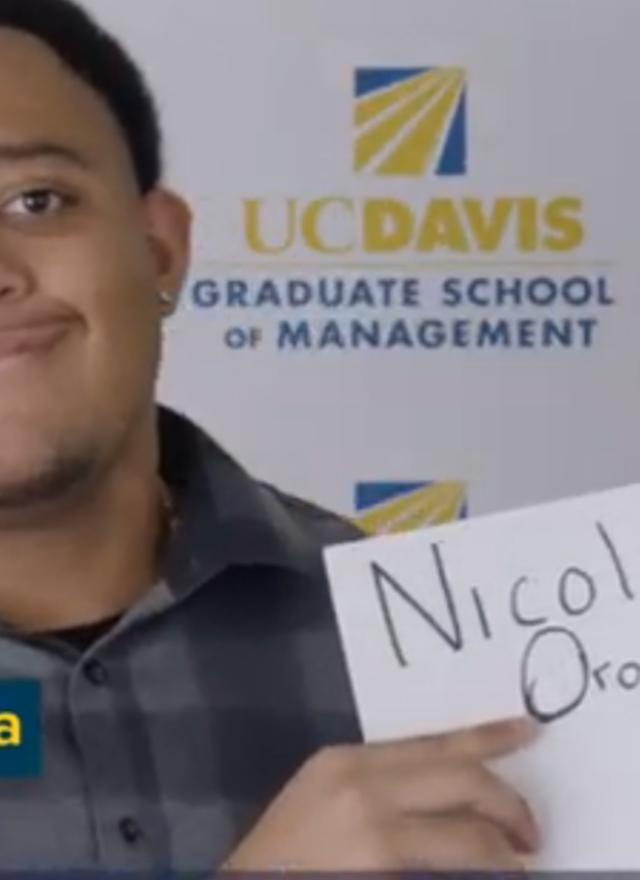 Nicolas holding up a sign with his name