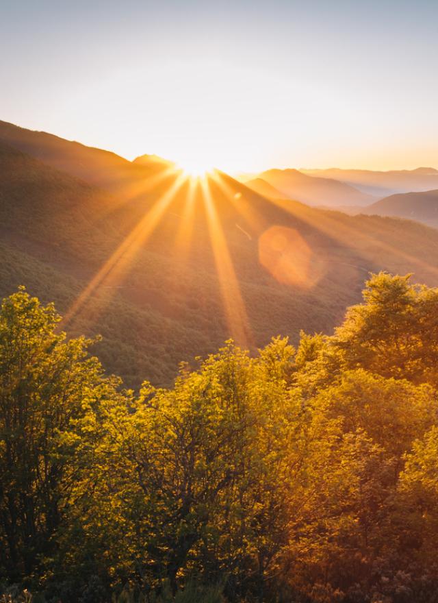 Scenic view of the sun rising over mountains stock photo