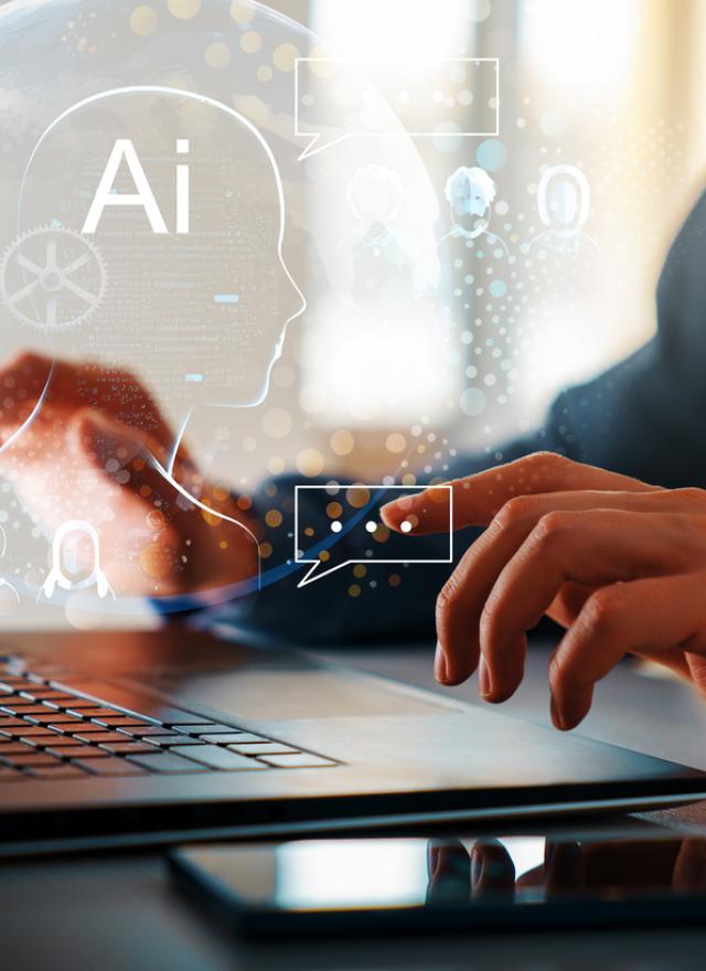 stock photo of hands displayed over a laptop with the text AI 