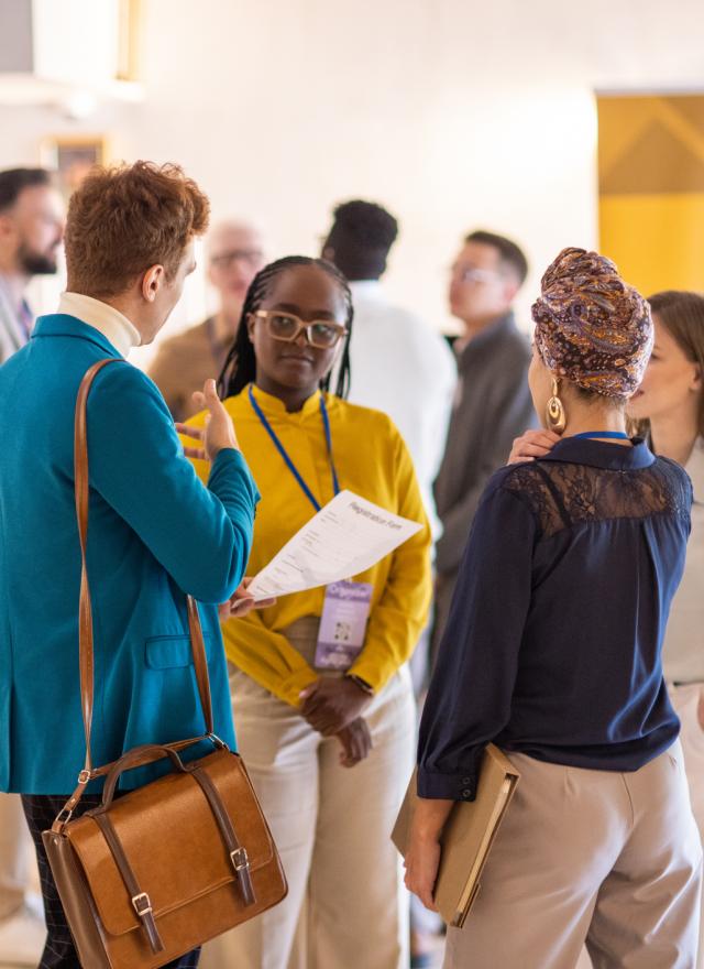 A group of business people casually talking in the lobby of a hotel before a business conference event starts