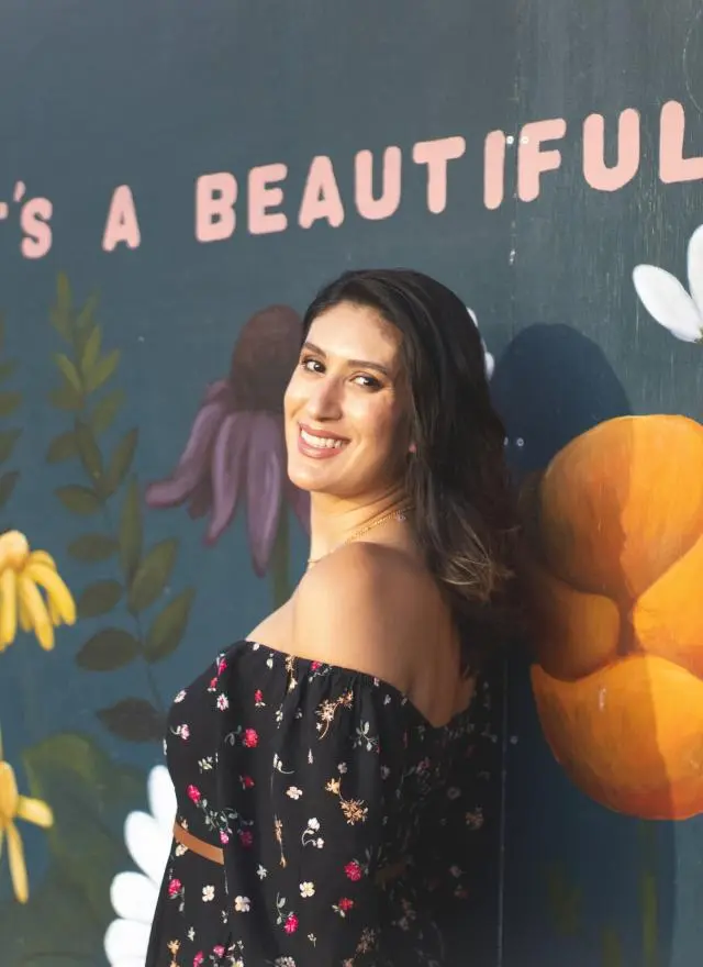 Leticia Garay standing in front of a flower mural