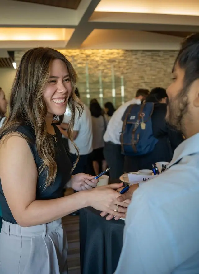 MBA students shaking hands in Gallagher Hall