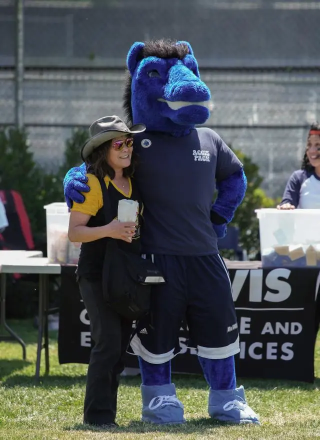 Gunrock the mascot and an UC Davis employee standing on Russell Field 