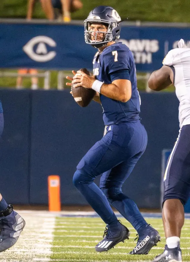 Miles Hastings holding a football on the field