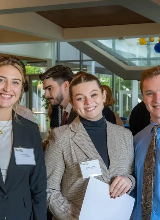 Three students in professional attire in Gallagher Hall