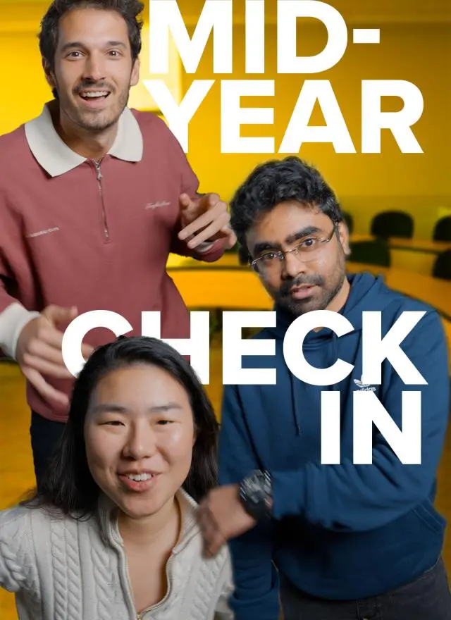 Three people facing the camera in a meeting room with "MID-YEAR CHECK IN" written in large white letters over the image.