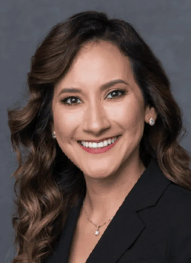 A woman in a black blazer smiles at the camera. Next to her is a “Poets & Quants MBAs to Watch Class of 2026” badge on a gray background.