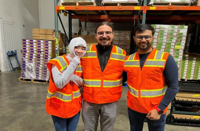 Sayar Banner Banerjee and two other students wearing safety vest at a warehouse