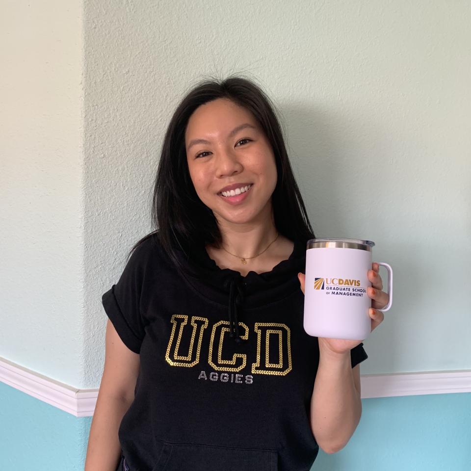 Kim-Mai Hoang shows off her UC Davis GSM coffee mug