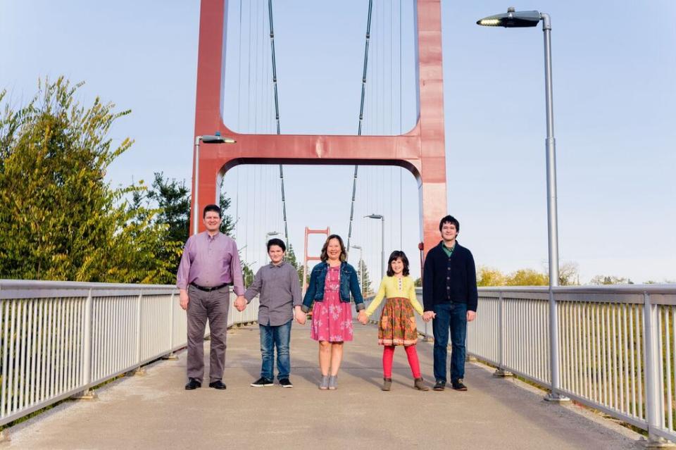 Matt Harris stands with is wife and children, holding hands on a bridge in Sacramento, California.