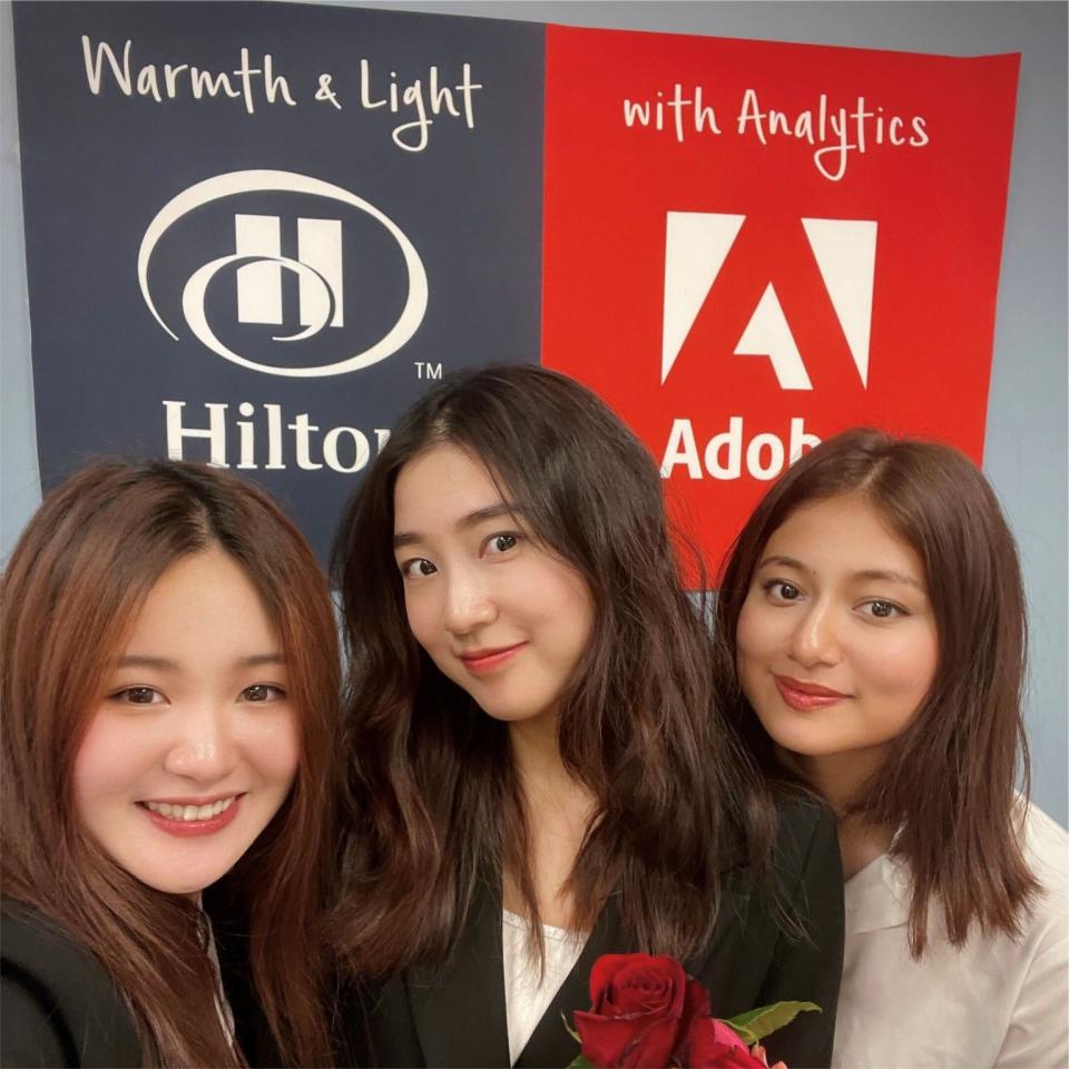 three women in front of adobe sign