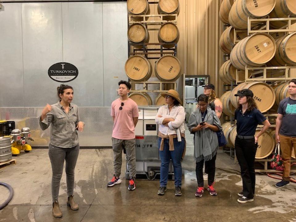 Group of people standing in a winery