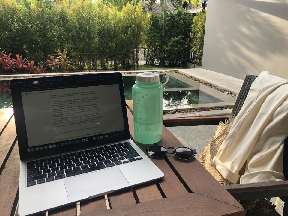 laptop and water bottle on an outdoor table