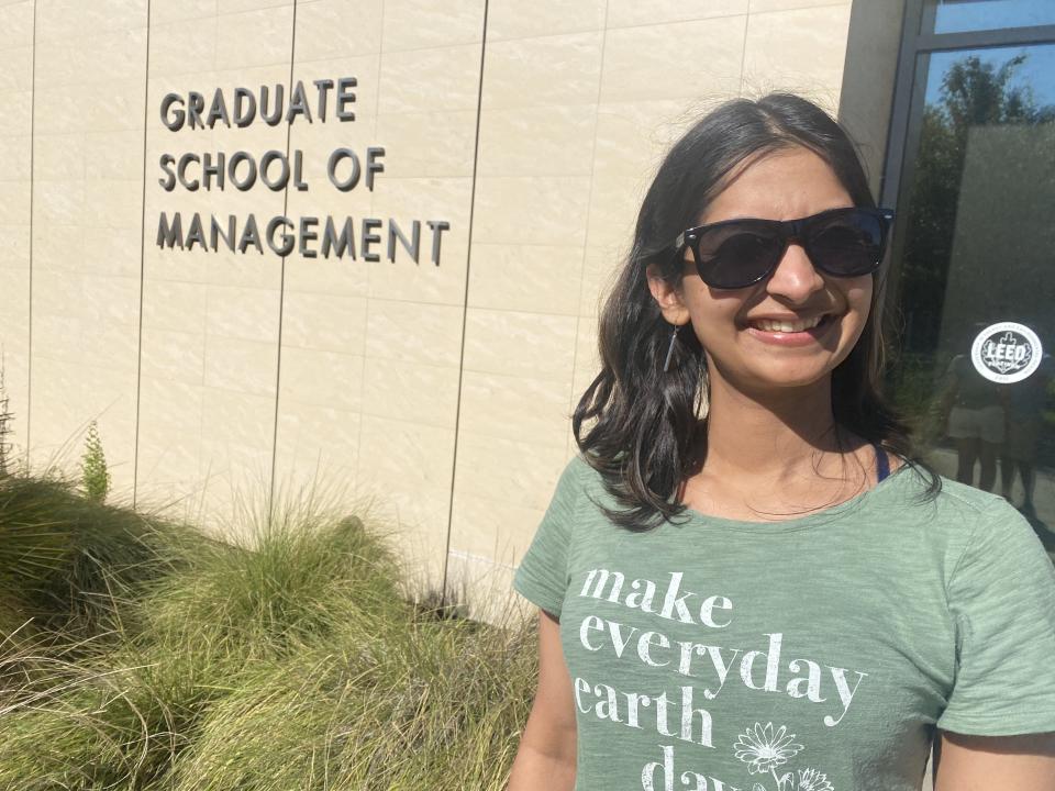 Woman standing in front of UC Davis's Graduate School of Management's Gallagher Hall