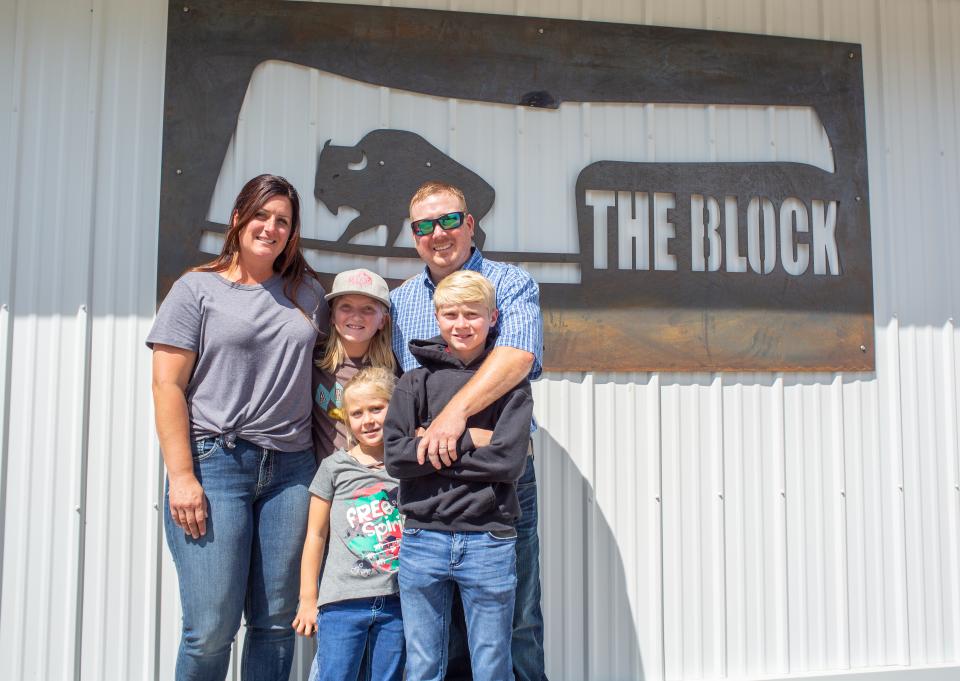 Williams family posing in front of their business sign