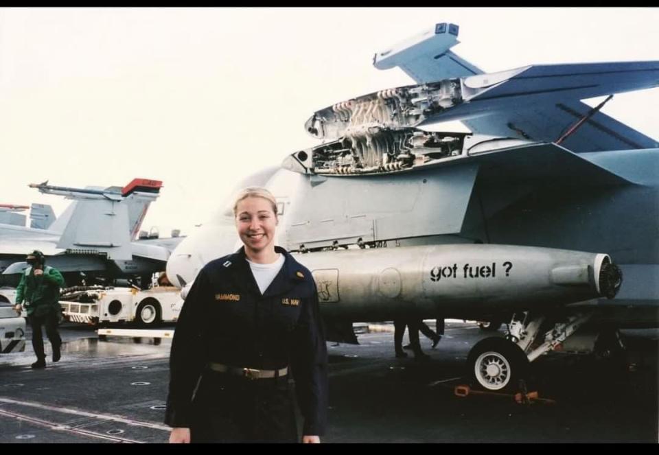 Lisa Hornick standing in front of an airplane at a military base