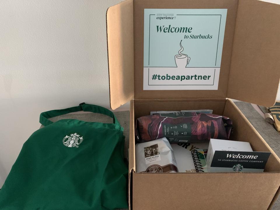 A swag bag of Starbucks products including an apron, coffee and merchandise