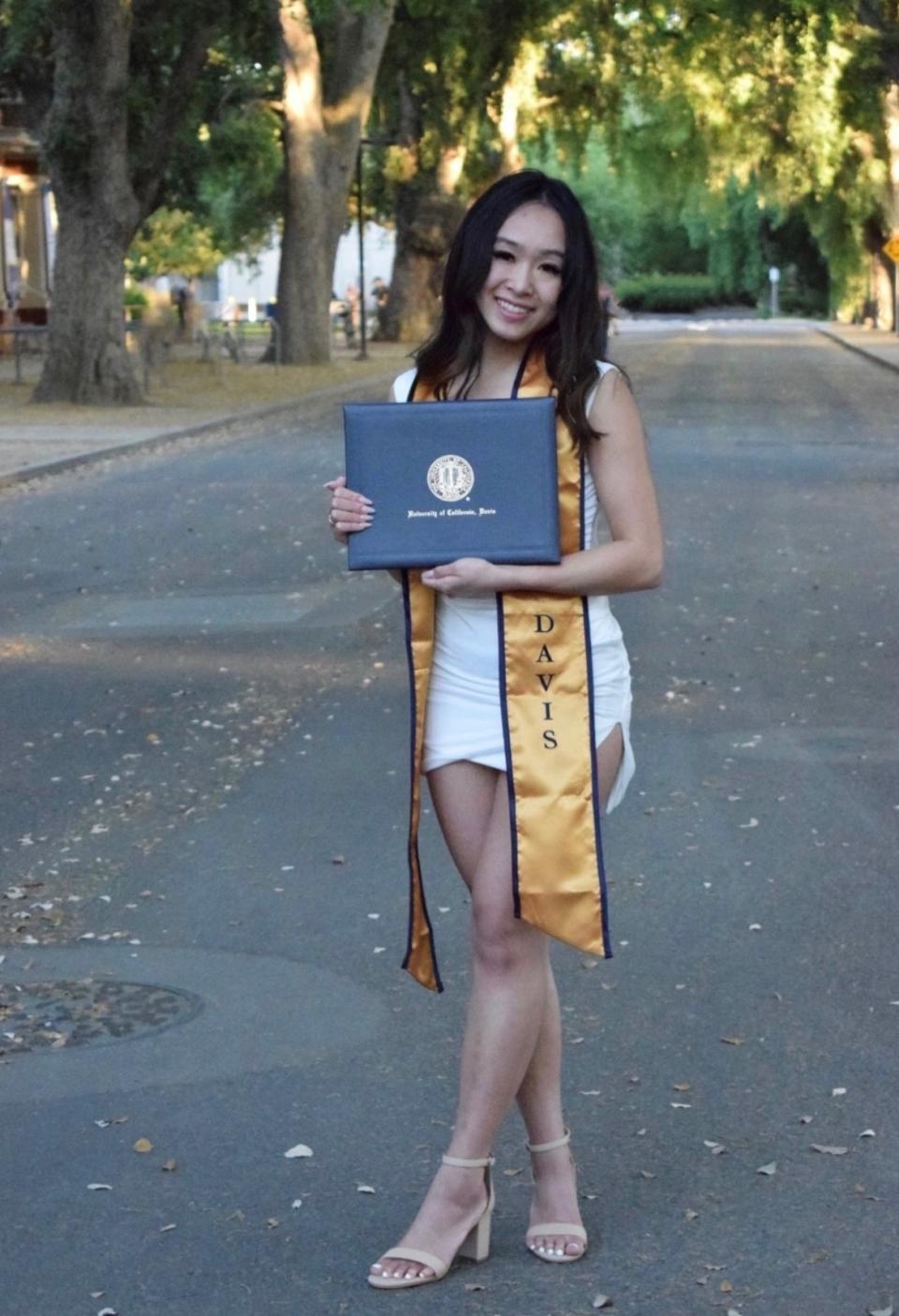 Diana Tran posing with her undergraduate diploma