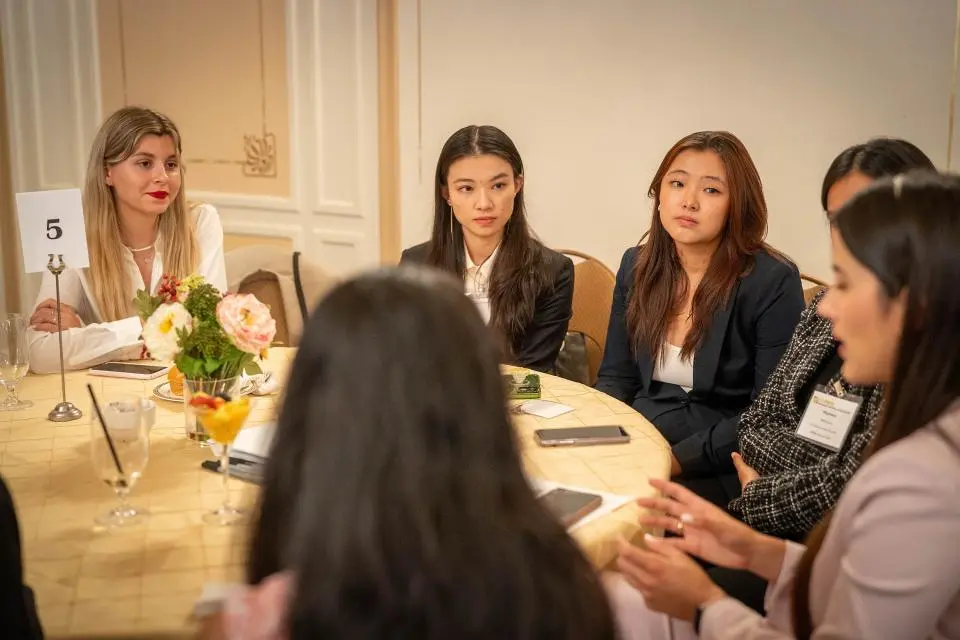 Amber Sillis with fellow students sitting at a roundtable at the GSM Speed Networking Event