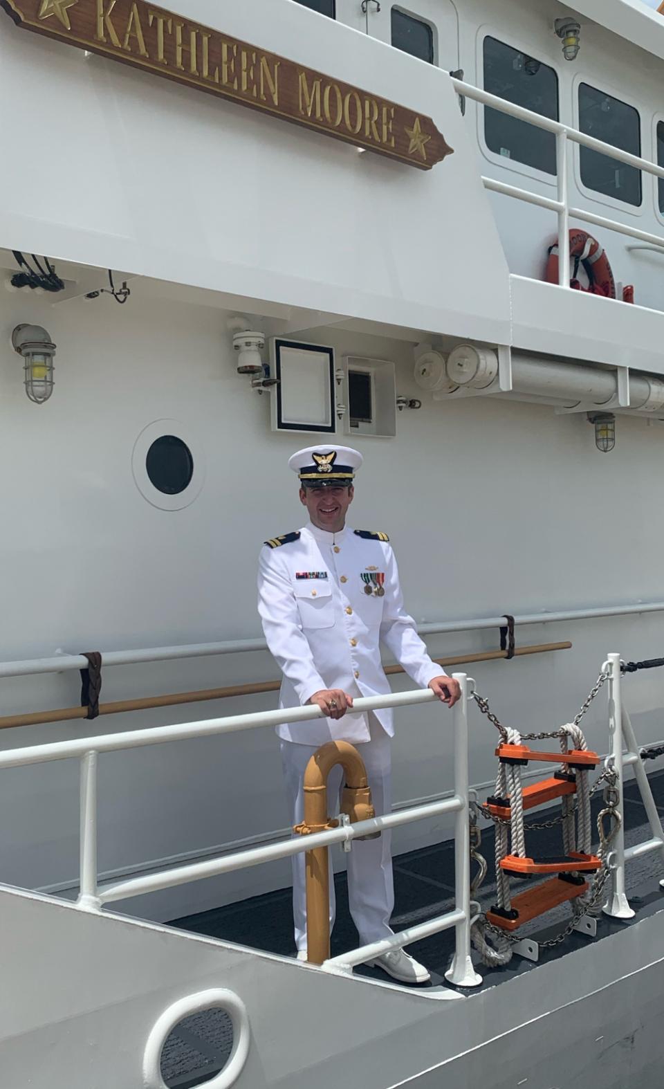 Andy Collins wearing a US Coast Guard uniform, standing on a shipdeck
