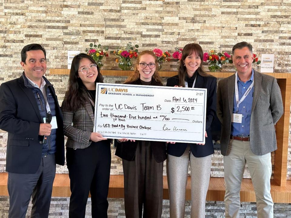 Daniella Kleiner-Kanter, Min Zhu and Marie Klein hold up a giant check for $2,500 with judges