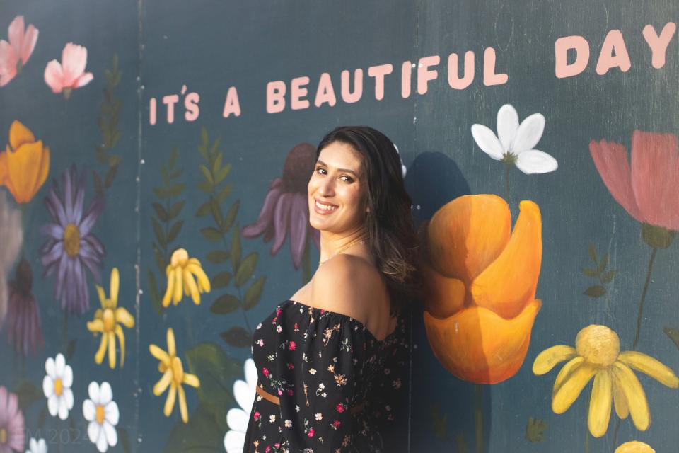 Leticia Garay standing in front of a flower mural