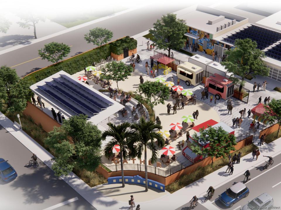 An aerial rendering of an outdoor community space featuring food trucks, seating areas with colorful umbrellas, greenery, and solar panel-covered structures. People are gathered throughout the space, socializing and enjoying the amenities. Cyclists and pedestrians are visible along the surrounding streets.