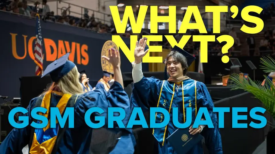 Two UC Davis graduates in caps and gowns high-five at a commencement ceremony. Large text reads "WHAT'S NEXT? GSM GRADUATES.