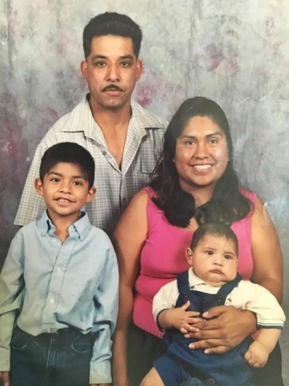 A family portrait of a man, a woman, and two children.
