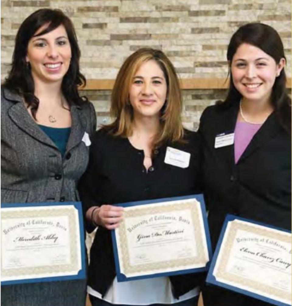 three women posing with award certificates
