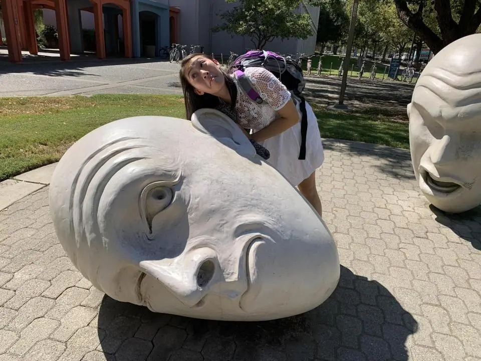 Jacqueleine Ngo with an egghead sculpture at the UC Davis campus