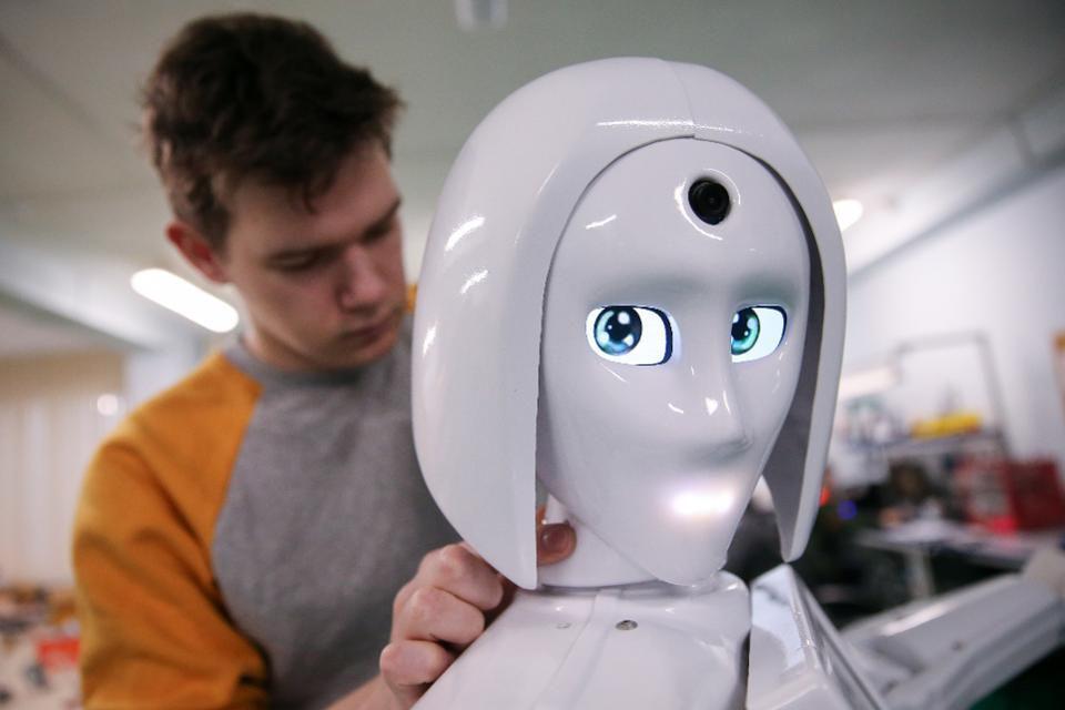 Male student repairing feminine robot