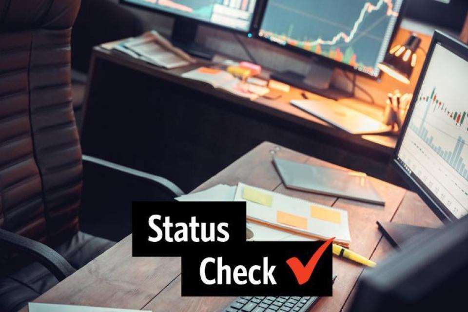 Office desk with 4 monitors and status check written in front
